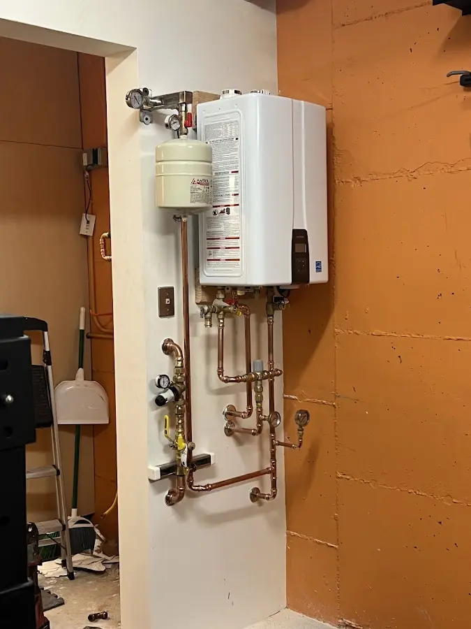 Plumbing technician inspecting water heater connections in Franklin Park